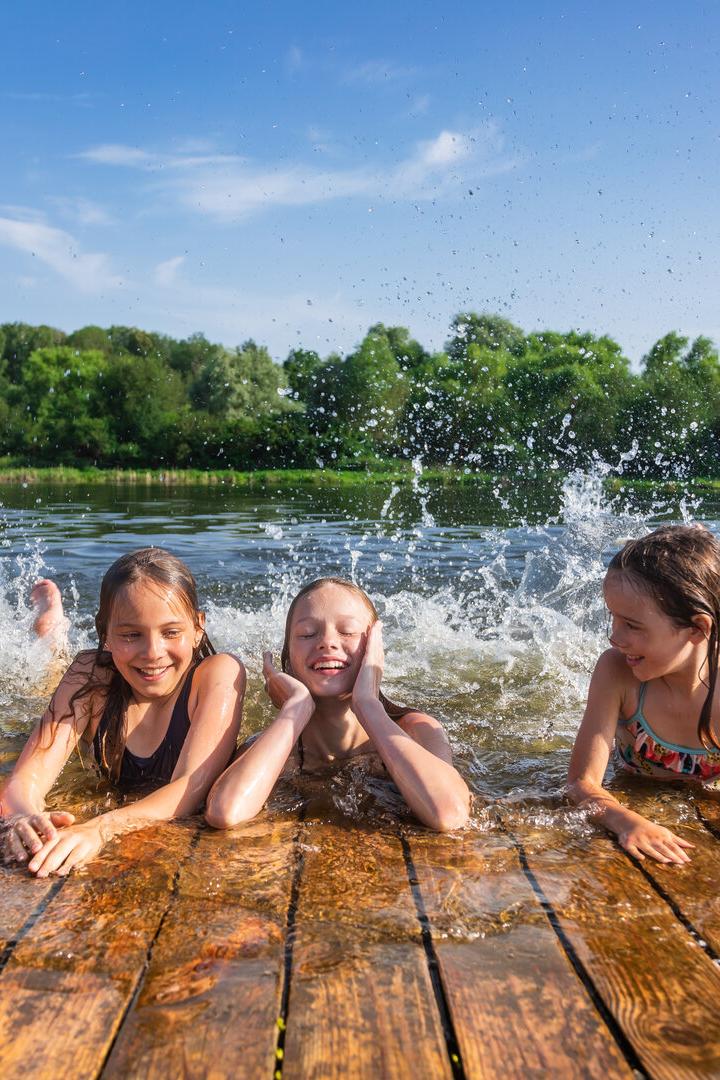Happy children enjoying summer holidays at a lake