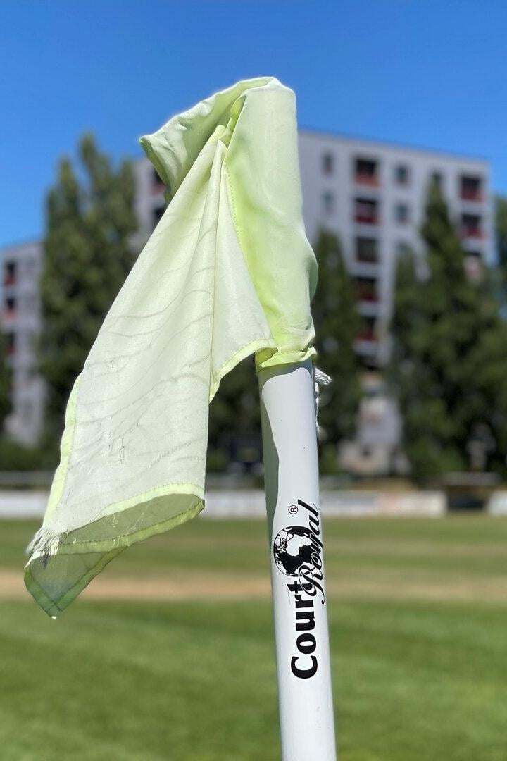 Eine Eckfahne auf einem Fußballfeld weht im Wind.
