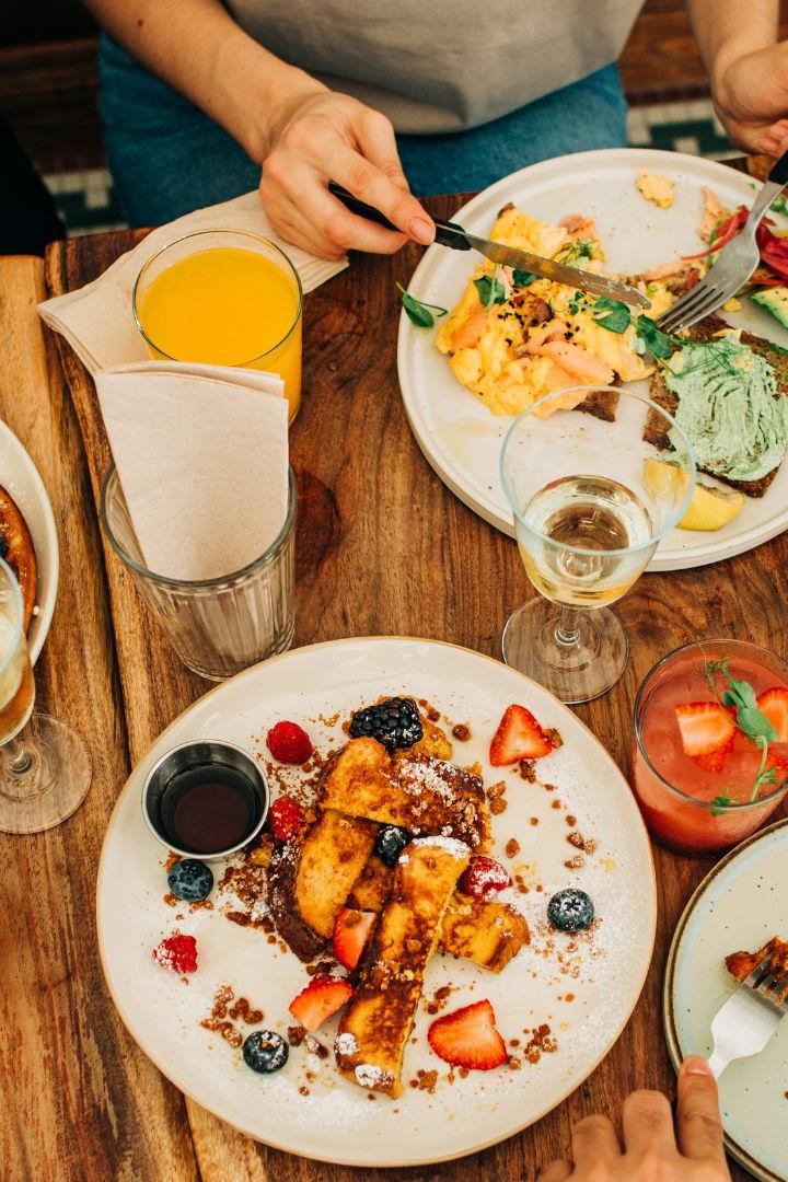 Brunchen am Land: Die Top 5 Lokale. Personen essen Frühstück am Tisch