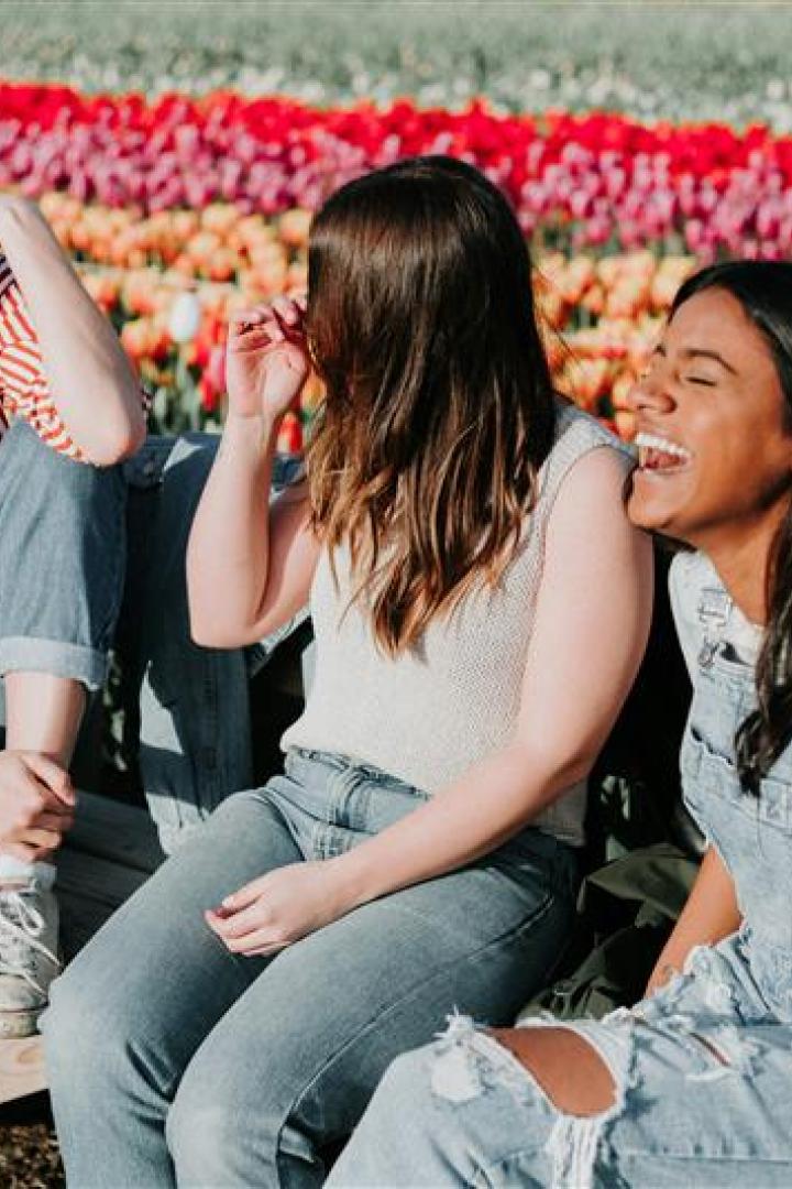 Frauen sitzen vor einem Blumenfeld