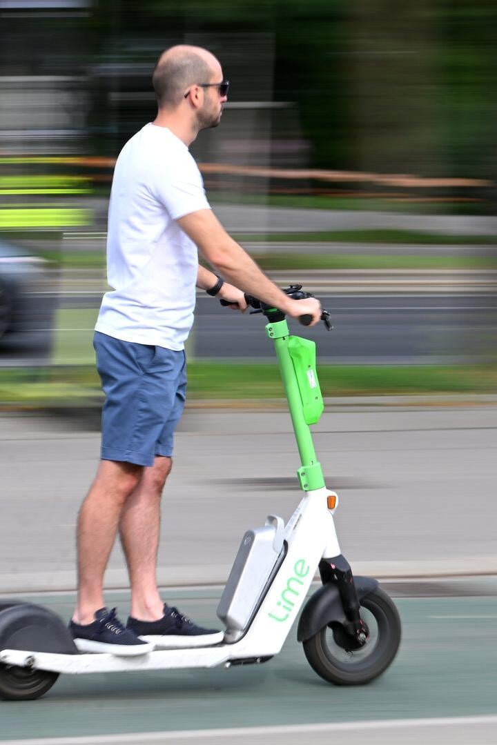 Mann auf E-Scooter ohne Helm