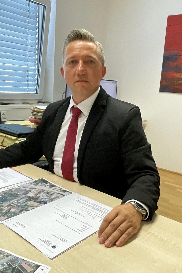 Anwalt Gerhard Ederer sitzt an seinem Schreibtisch und arbeitet an Dokumenten.
