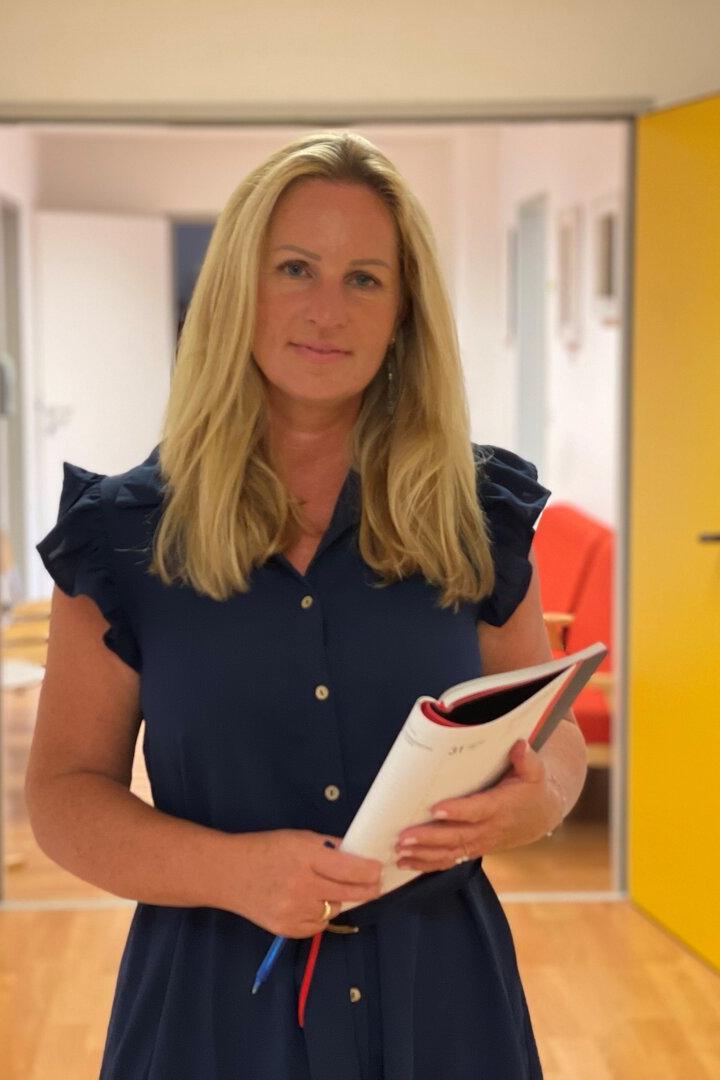 Claudia Holub im Vereinsbüro mit einer Mappe in der Hand.
