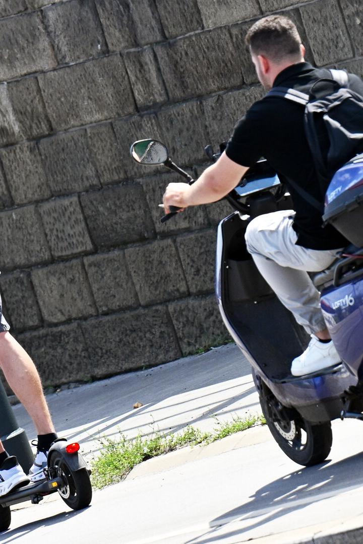 Zwei Personen fahren mit E-Scooter und E-Moped auf der Straße.