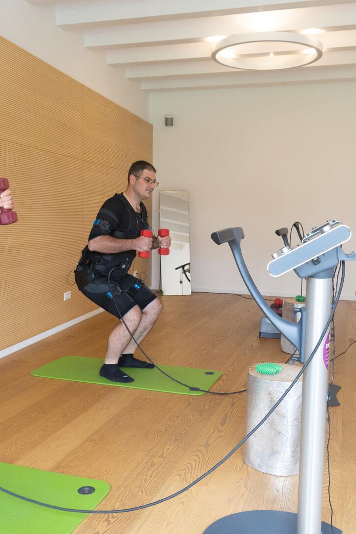 Das Bild zeigt Dagmar Paß und Rudolf Grubauer beim medizinischen EMS-Training mit der Trainerin Julia Codet, die rechts im Bild zu sehen ist:  erfolgreiche Therapie der Rückenschmerzen.