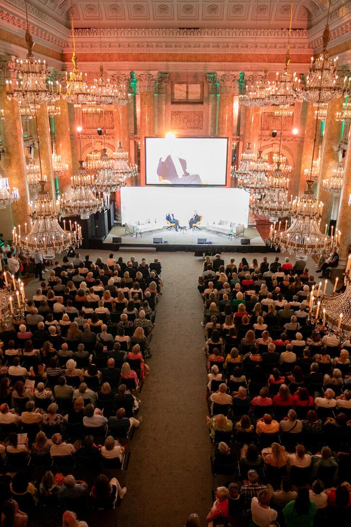 Ein großer Saal der Wiener Hofburg mit Lustern und vielen Menschen