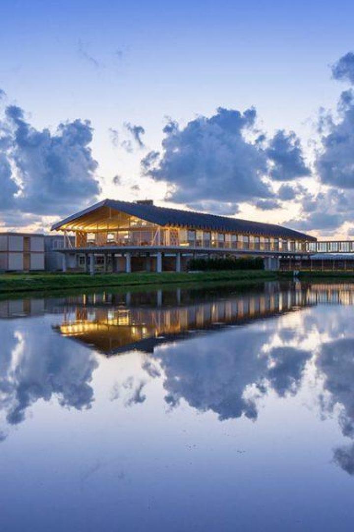 Das Shonai Suiden Terrasse Hotel, entworfen von Shigeru Ban, spiegelt sich im Wasser.