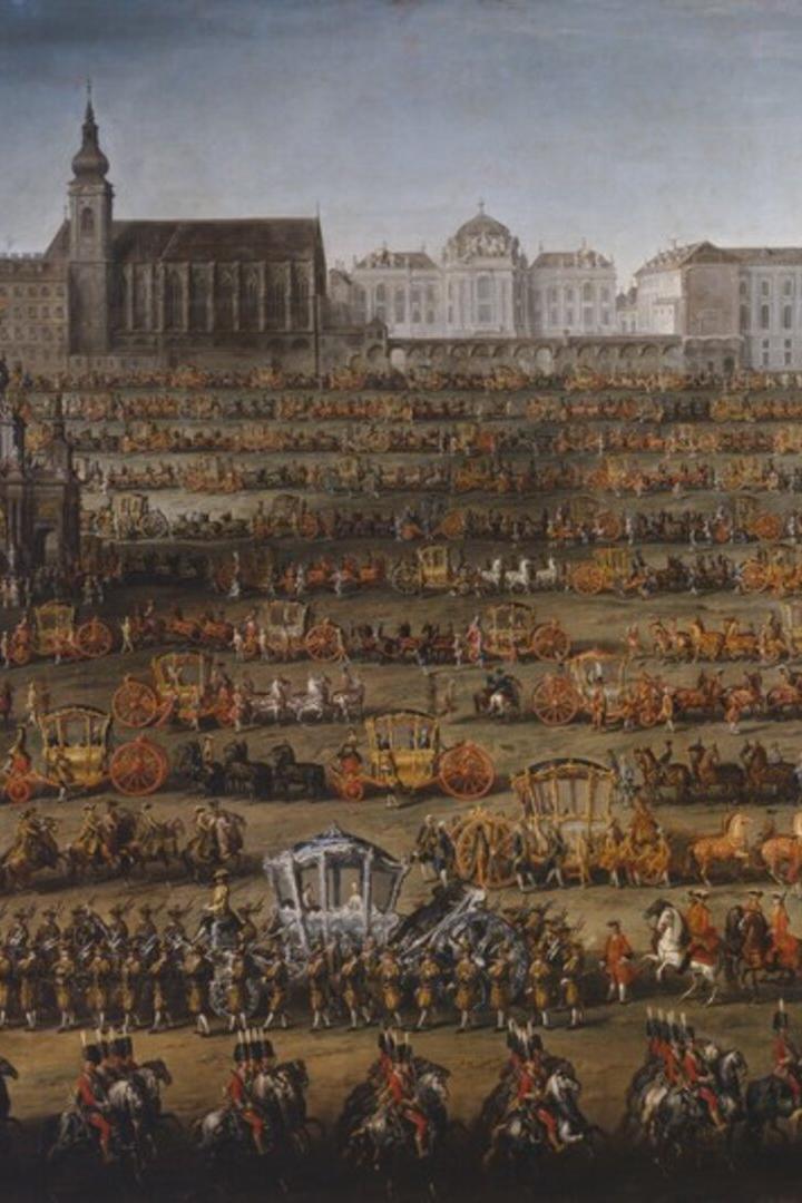 Eine lange Prozession von Kutschen und Reitern zieht durch Wien, im Hintergrund die Hofburg.