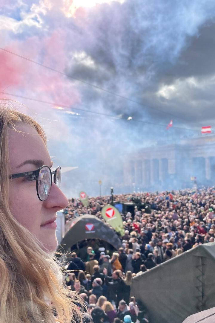 Eine junge Frau beobachtet die Parade auf dem Heldenplatz.