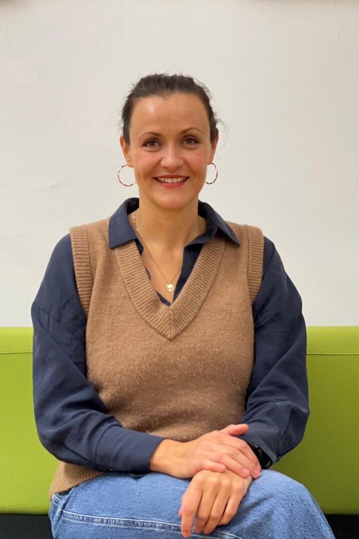 Kathrin Unterhofer sitzt auf einer grünen Couch und lächelt.