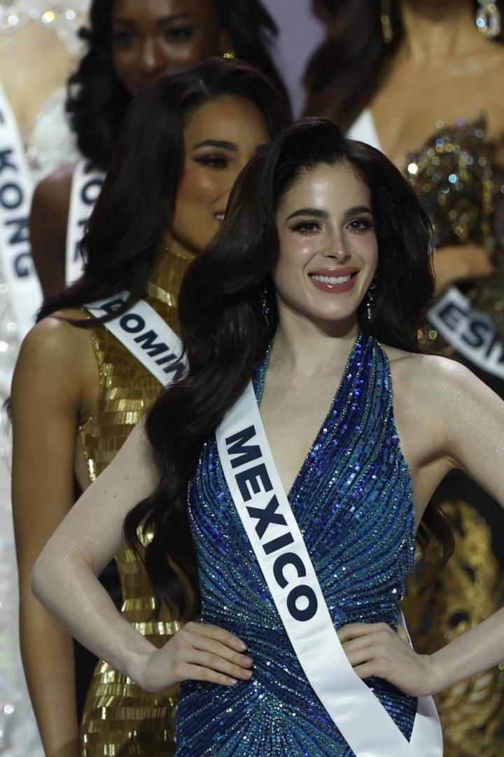 Eine strahlende Teilnehmerin mit der Schärpe "MEXICO" posiert in einem glitzernden, blauen Kleid.