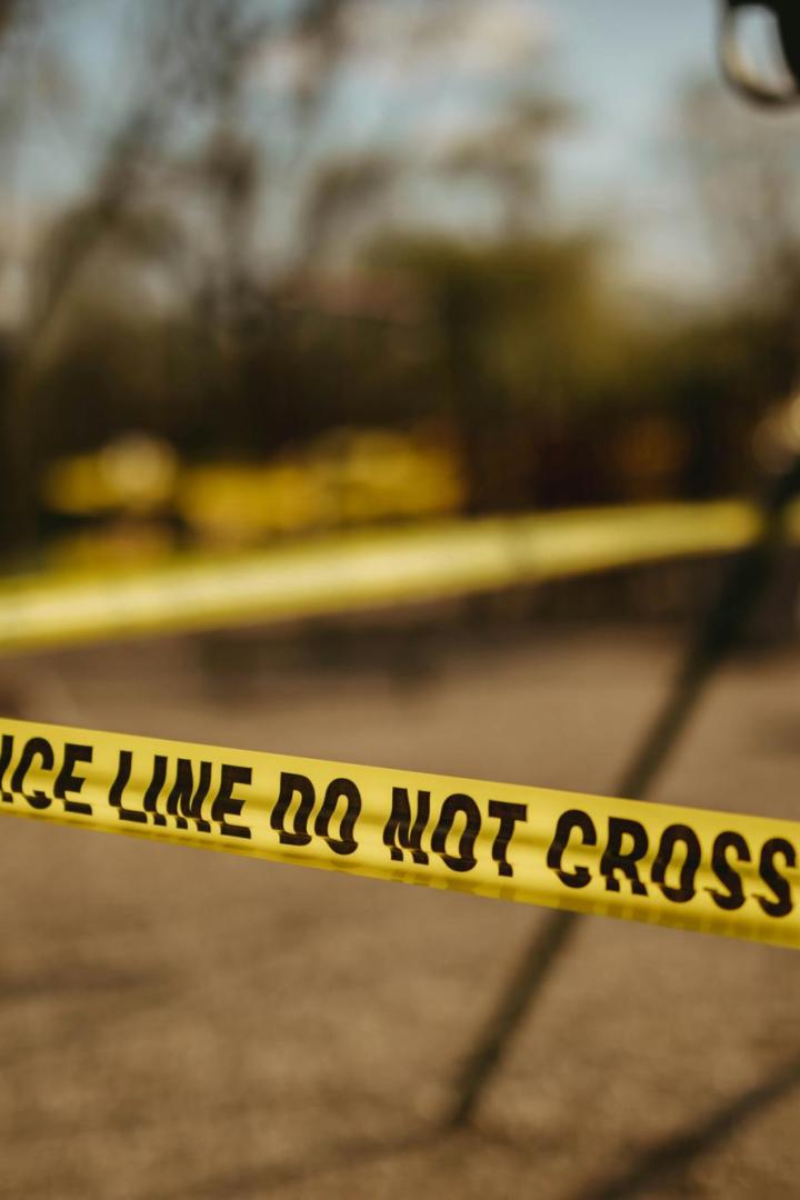 Gelbes Polizeiabsperrband zwischen Bäumen