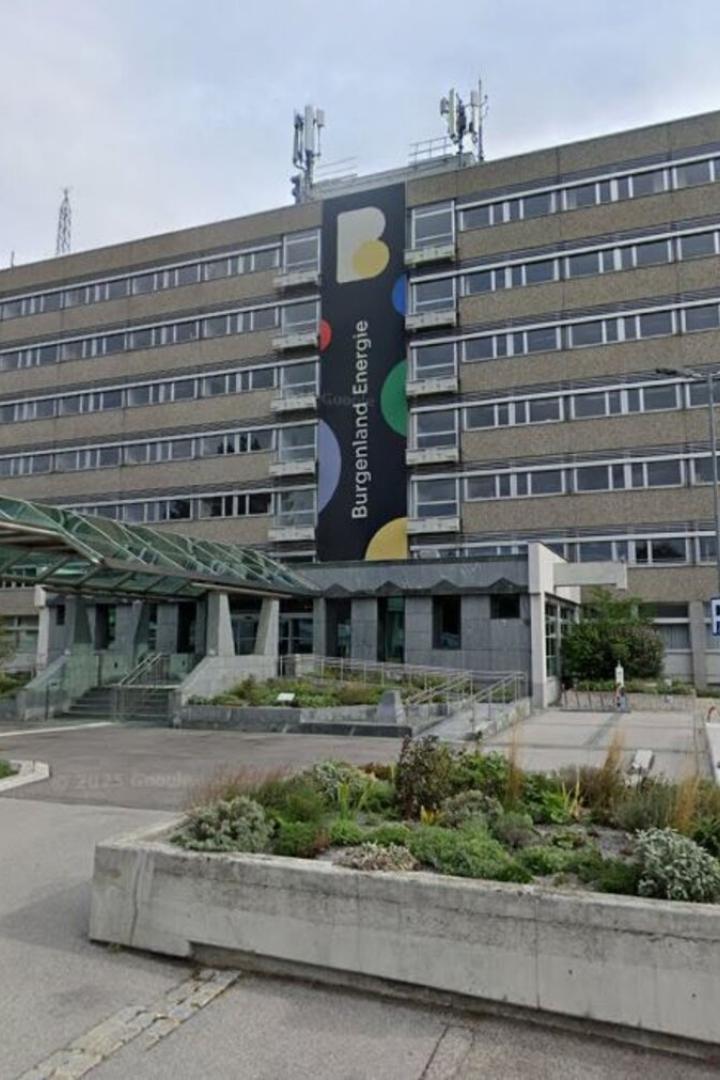Ein mehrstöckiges Bürogebäude mit moderner Glasüberdachung am Eingang und dem Schriftzug „Burgenland Energie“.