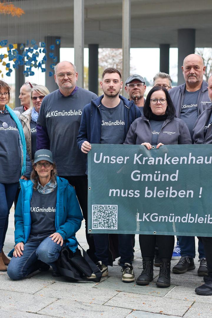 Mehrere Personen vom Verein "LK Gmünd bleibt" stehen vor dem Landtag und halten ein Transparent, auf dem "Unser Krankenhaus Gmünd muss bleiben!" zu lesen ist.