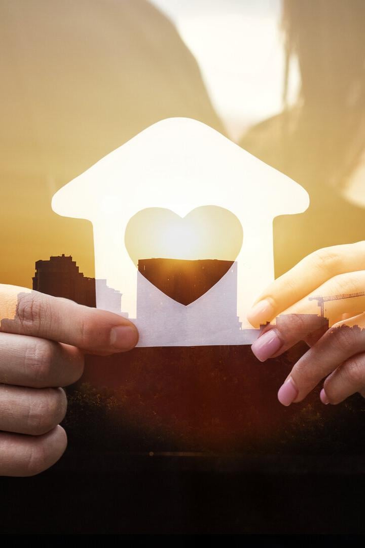 Paar hält das gemeinsame Haus in Händen.