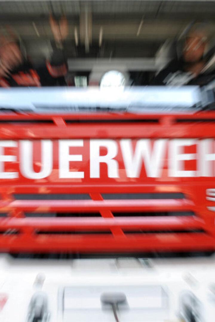 Ein rotes Feuerwehrfahrzeug mit der Aufschrift "FEUERWEHR" ist zu sehen.