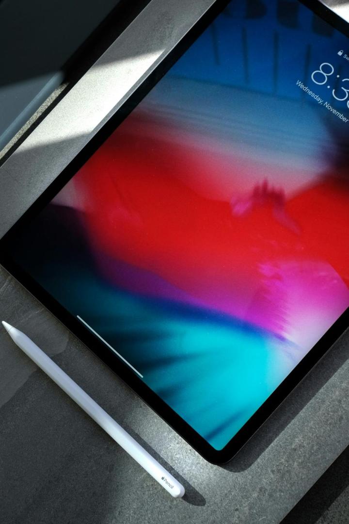 Ein iPad mit Apple Pencil liegt auf einer grauen Oberfläche im Sonnenlicht.