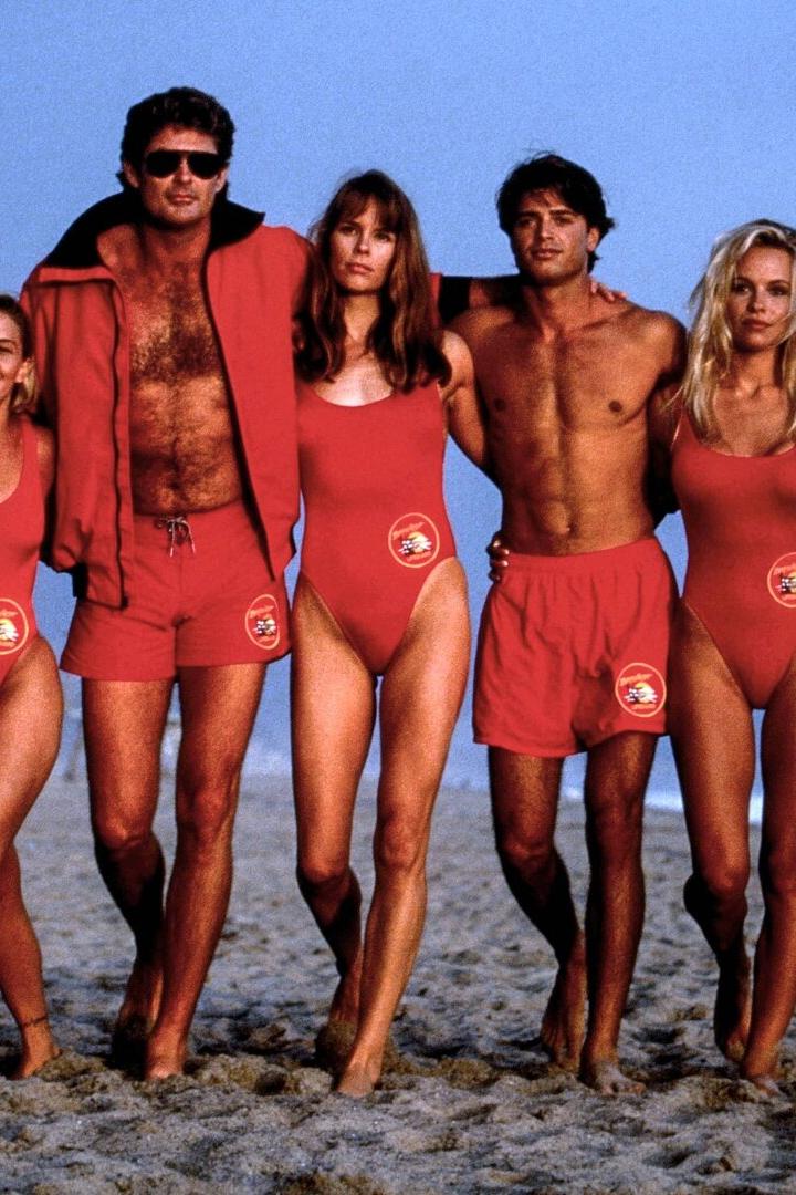 Die Rettungschwimmer aus den Neunzigern am Strand - sie haben sich ihre Arme um die Schultern gelegt.