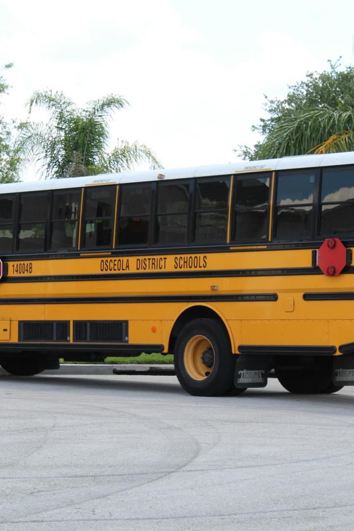 Ein gelber Schulbus steht an einer Straßenecke.