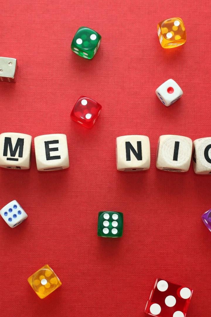 Wooden word dice spell 'Game Night' with multicoloured dice around it.