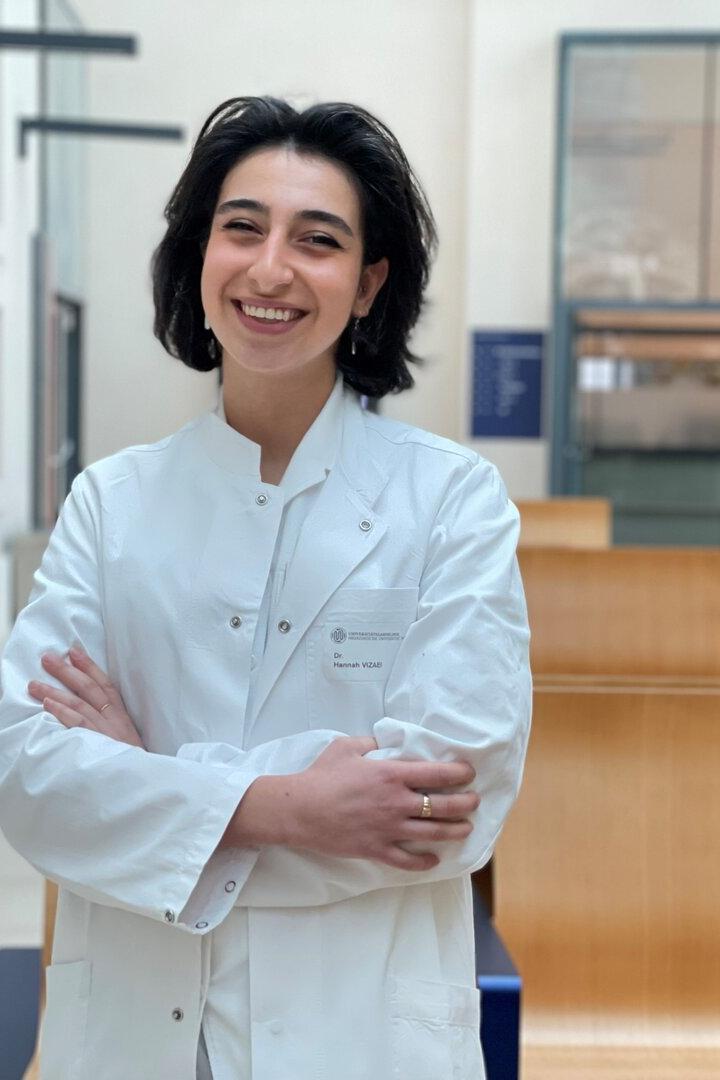 Hannah  Vizaei steht in einem langen hellen Gang der Wiener Zahnklinik.