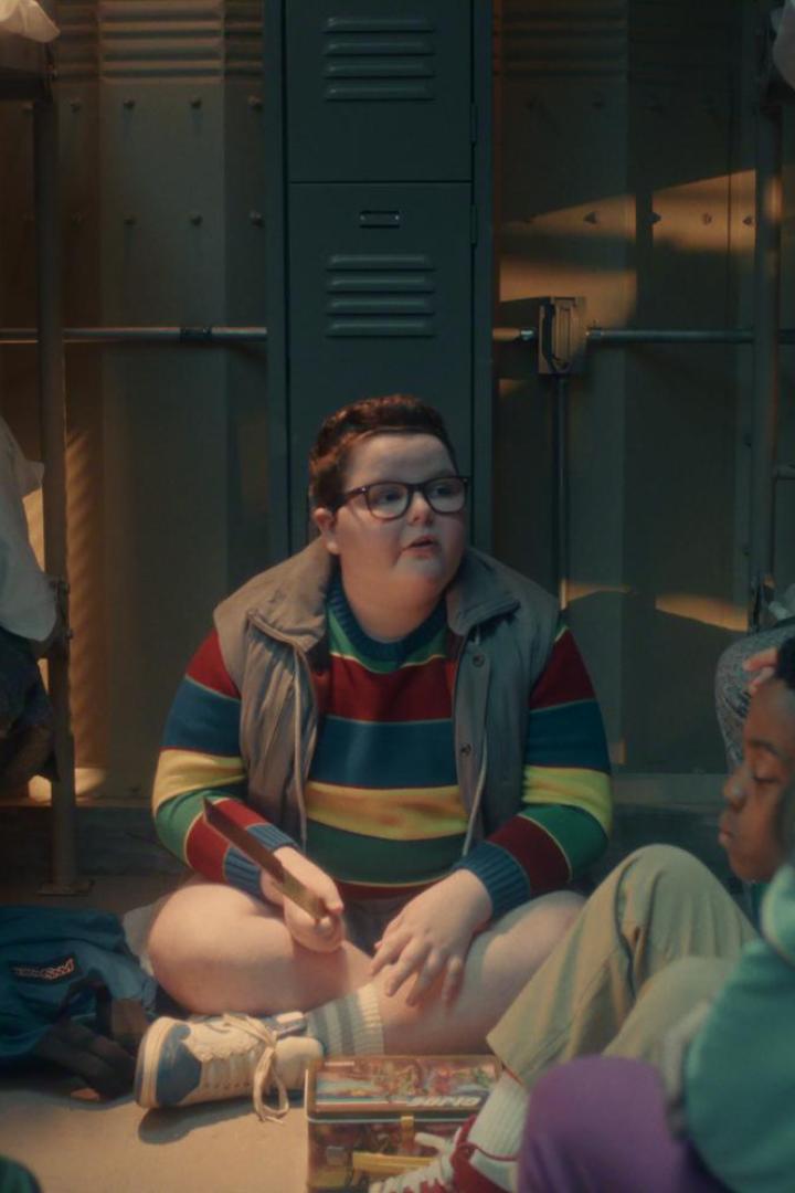 Mehrere Kinder sitzen in einem Schlafsaal im Kreis auf dem Boden zwischen Etagenbetten und unterhalten sich.