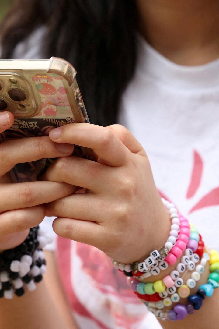 FILE PHOTO: Teens discuss Australia's social media ban for under-16s, set to take effect December 10, in Sydney