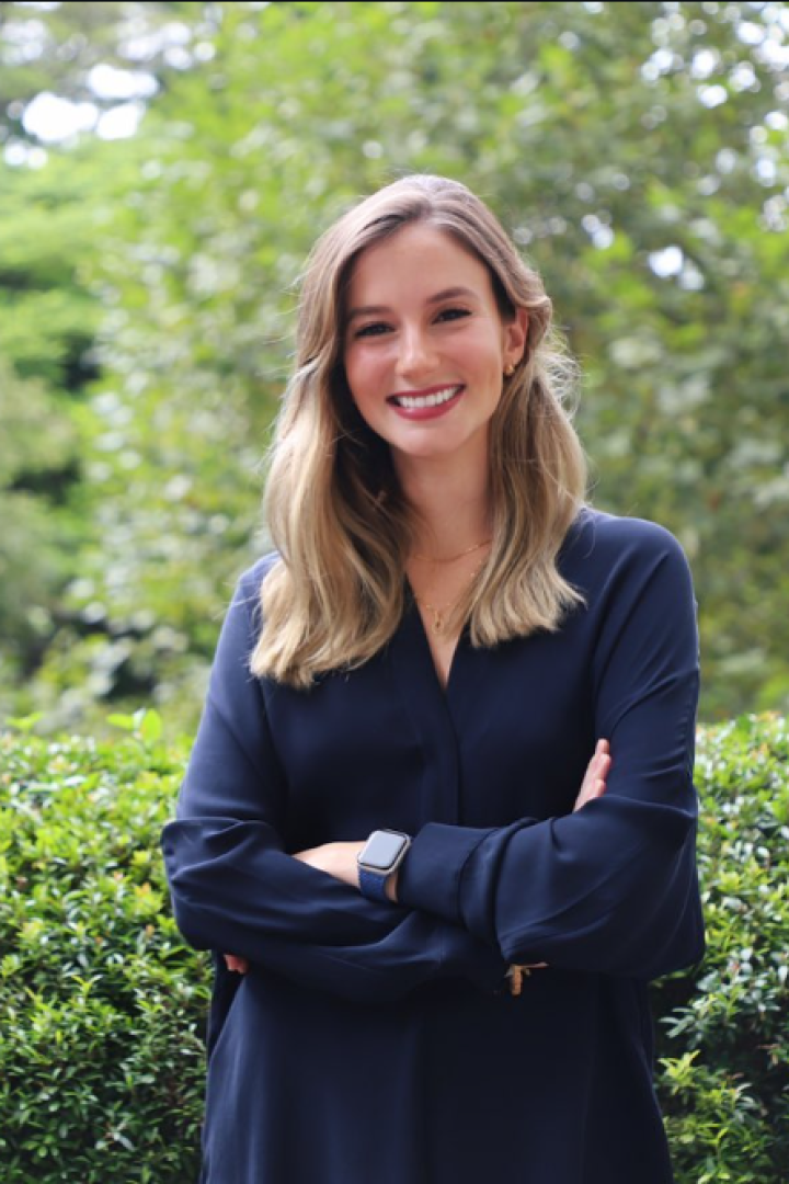 Luana Lopes Lara im Porträt-Format vor Garten.