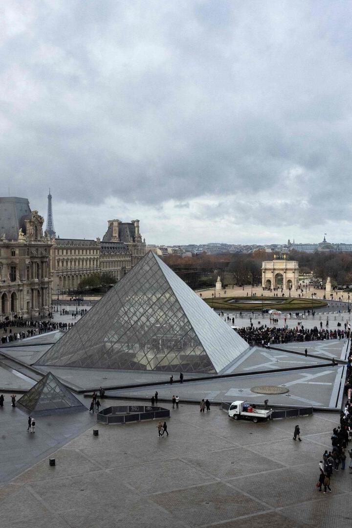 Die Glaspyramide im Louvre-Museum in Paris ist von Menschen umgeben.