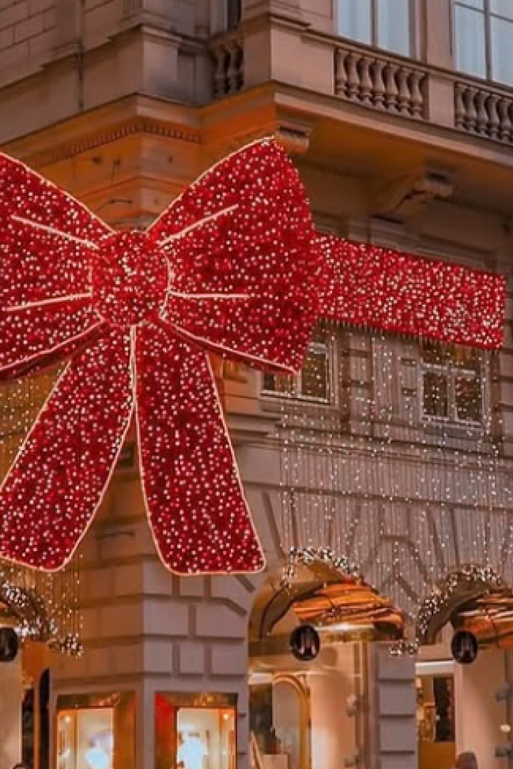 Riesige rote Weihnachtsschleife mit Lichterketten an einem Eckhaus auf der Kärntner Straße.