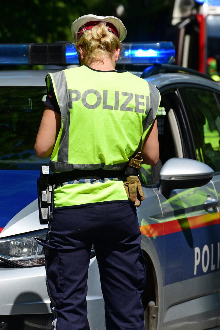 Polizistin vor Polizeiauto