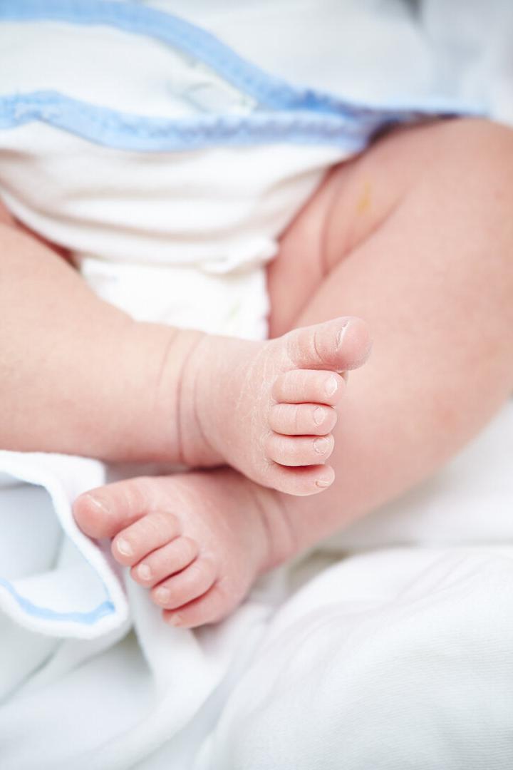 Babyfüße in einem Bett.