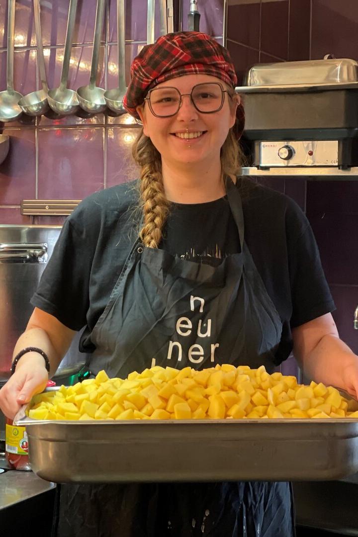 Svenja Knisel mit einem Blech gefüllt mit geschälten Kartoffeln.