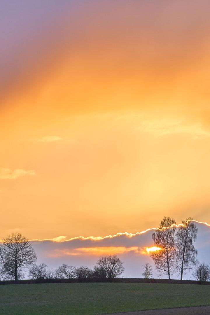 Das Bild zeigt eine ruhige Landschaft, einen orangen Himmel, es vermittelt Stille und Besinnlichkeit.