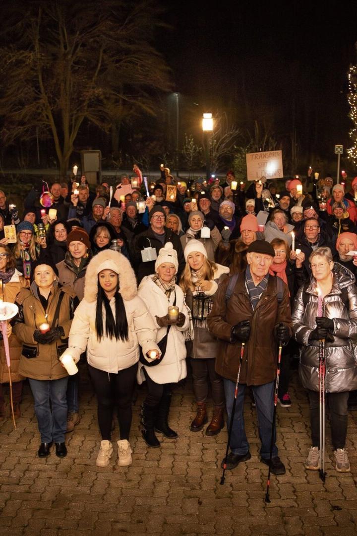 Eine Menschenmenge steht auf einer Wiese.
