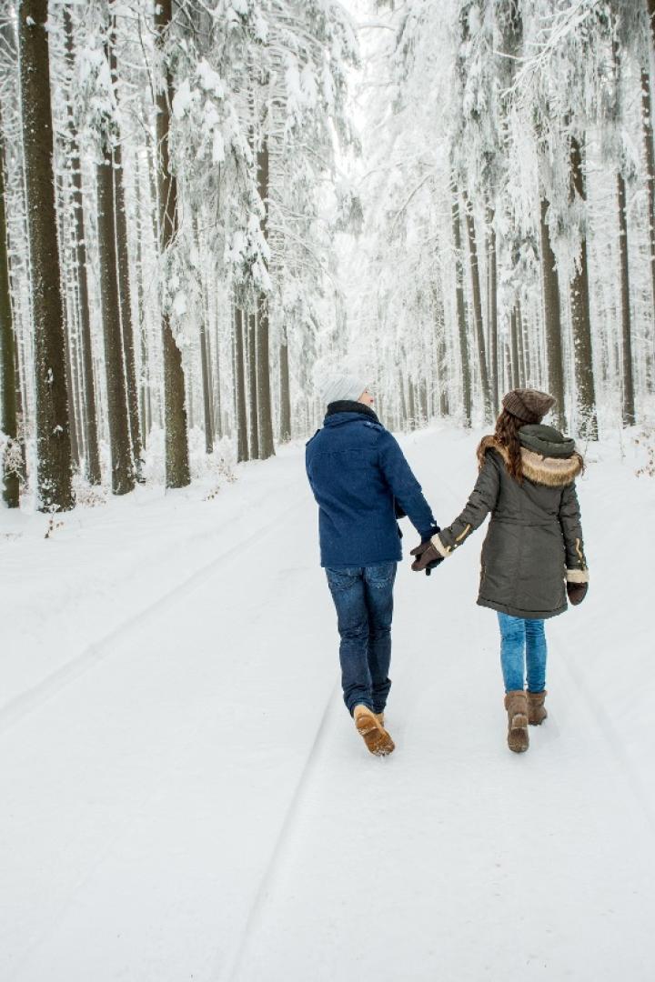 Paar spaziert im verschneiten Wald