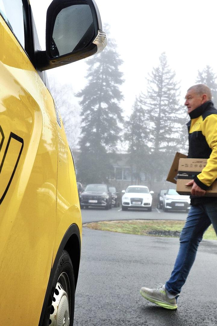 Zeigt Briefträger bei Arbeit.