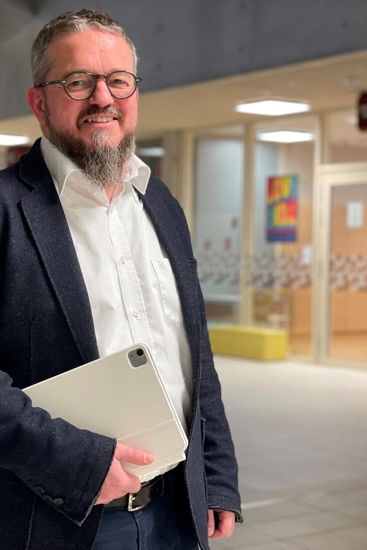 Markus Neuherz steht in der Aula der Schule, in der er unterrichtet.