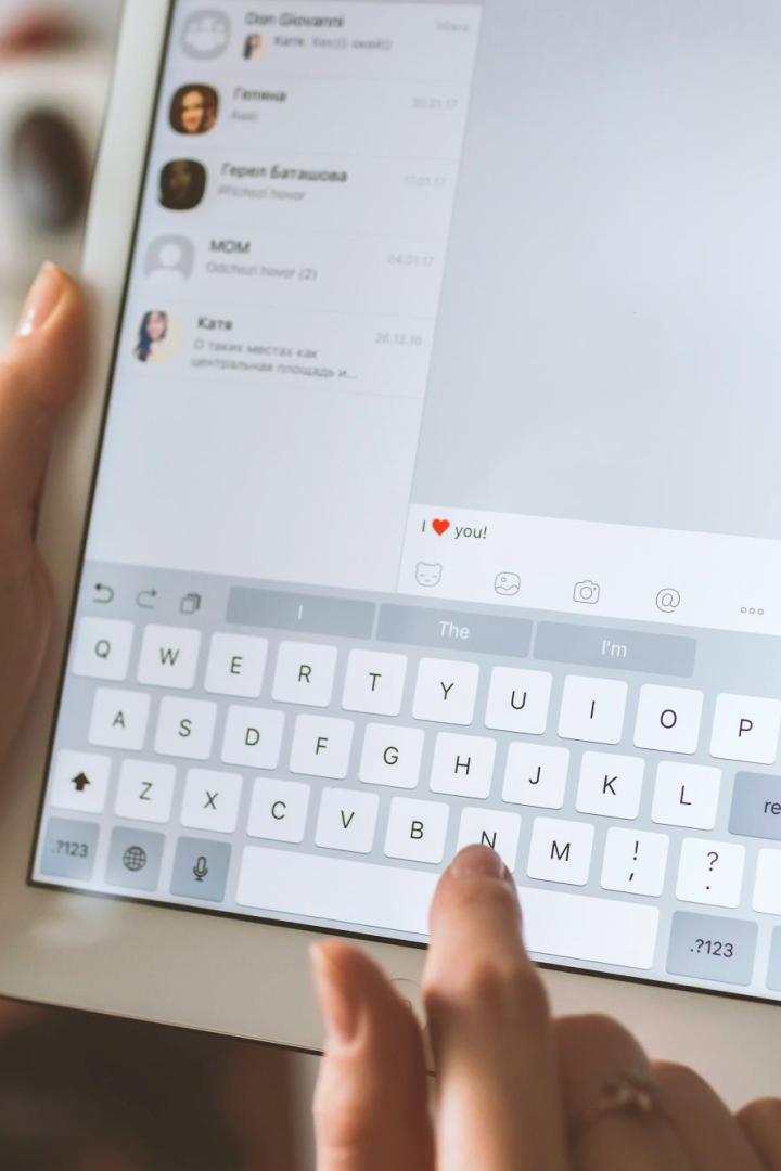 Person schreibt auf einem Tablet auf Englisch die Nachricht "Ich liebe dich"