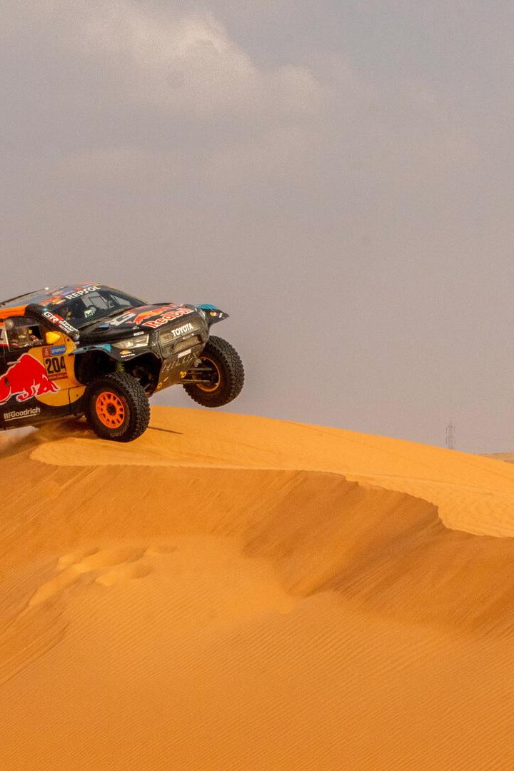 Ein Auto fährt bei der Rallye Dakar über eine Sanddüne.