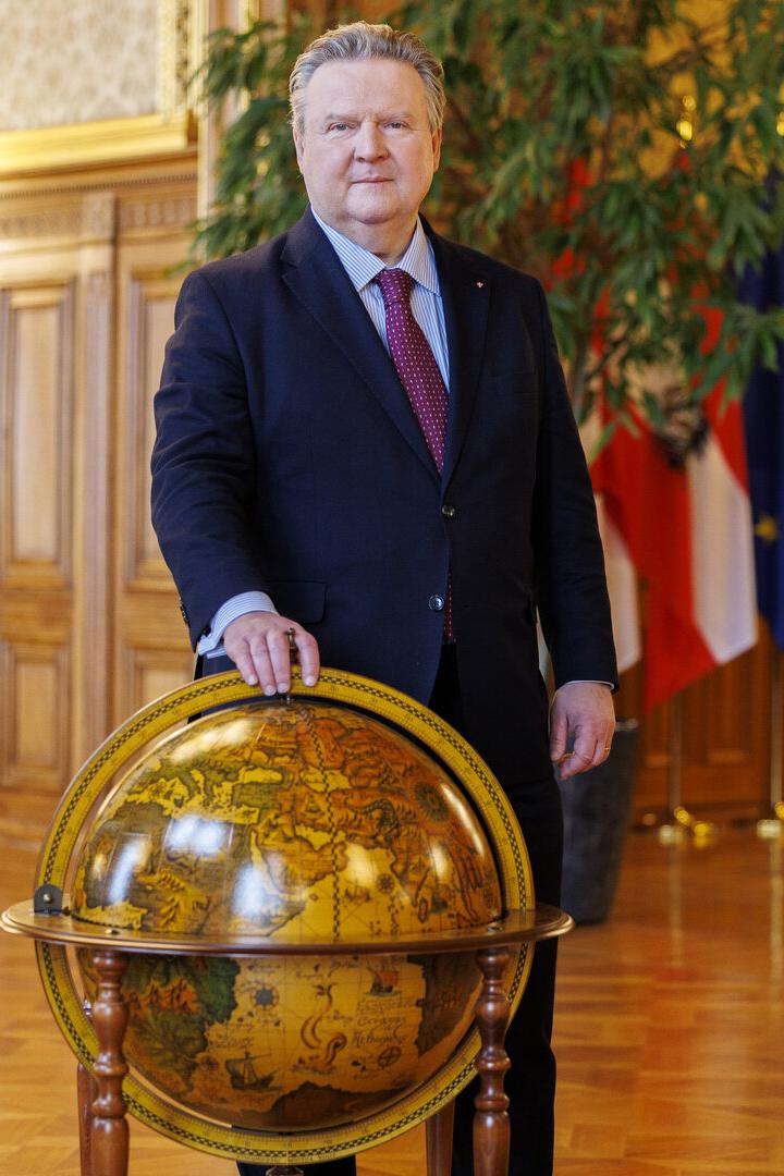 Michael Ludwig im Anzug steht in einem prunkvollen Saal neben einem großen Globus.