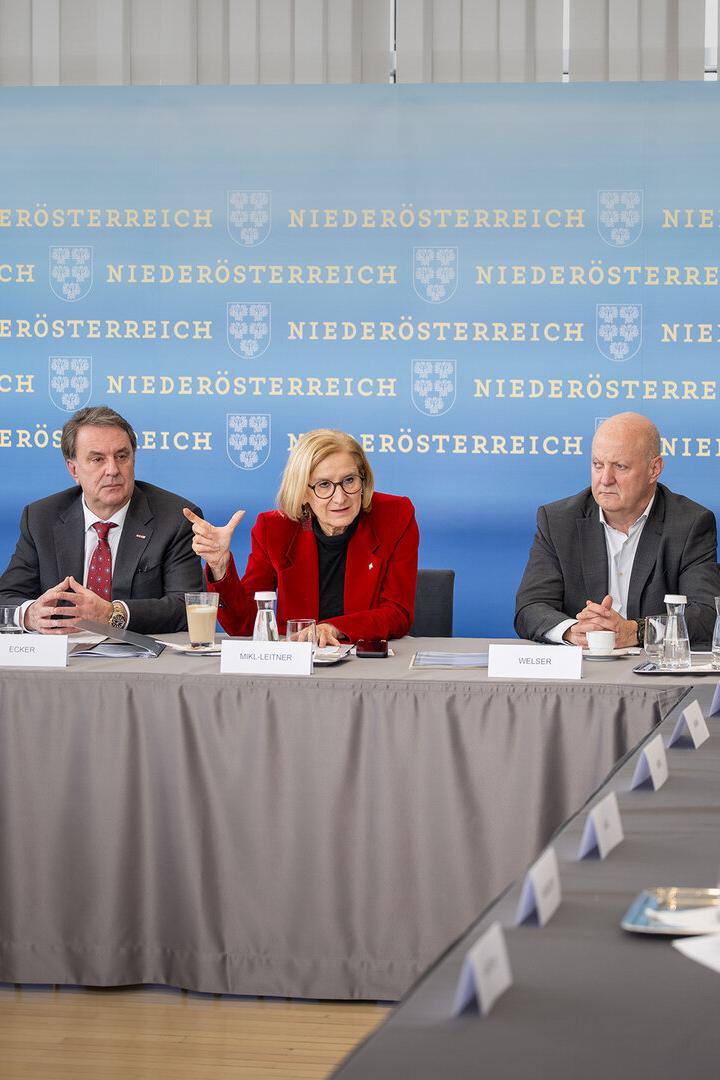 Eine Gruppe von Personen, darunter Mikl-Leitner, sitzt an einem Tisch vor einem Hintergrund mit dem Schriftzug "Niederösterreich".