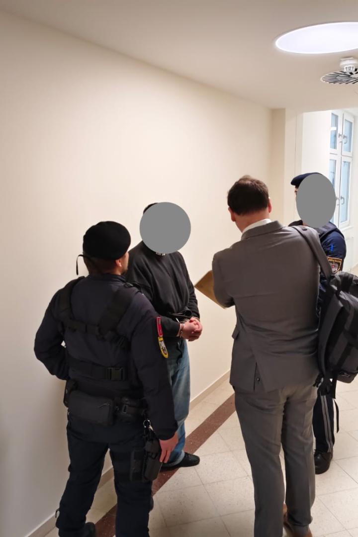 Angeklagter und Justizwachebeamte.