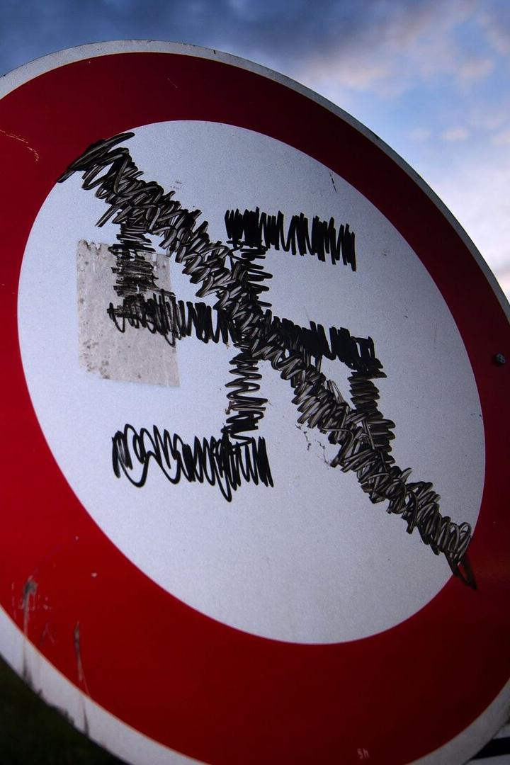 Verkehrsschild mit rotem Rand, dessen Symbol mit schwarzem Filzstift unkenntlich gemacht wurde.