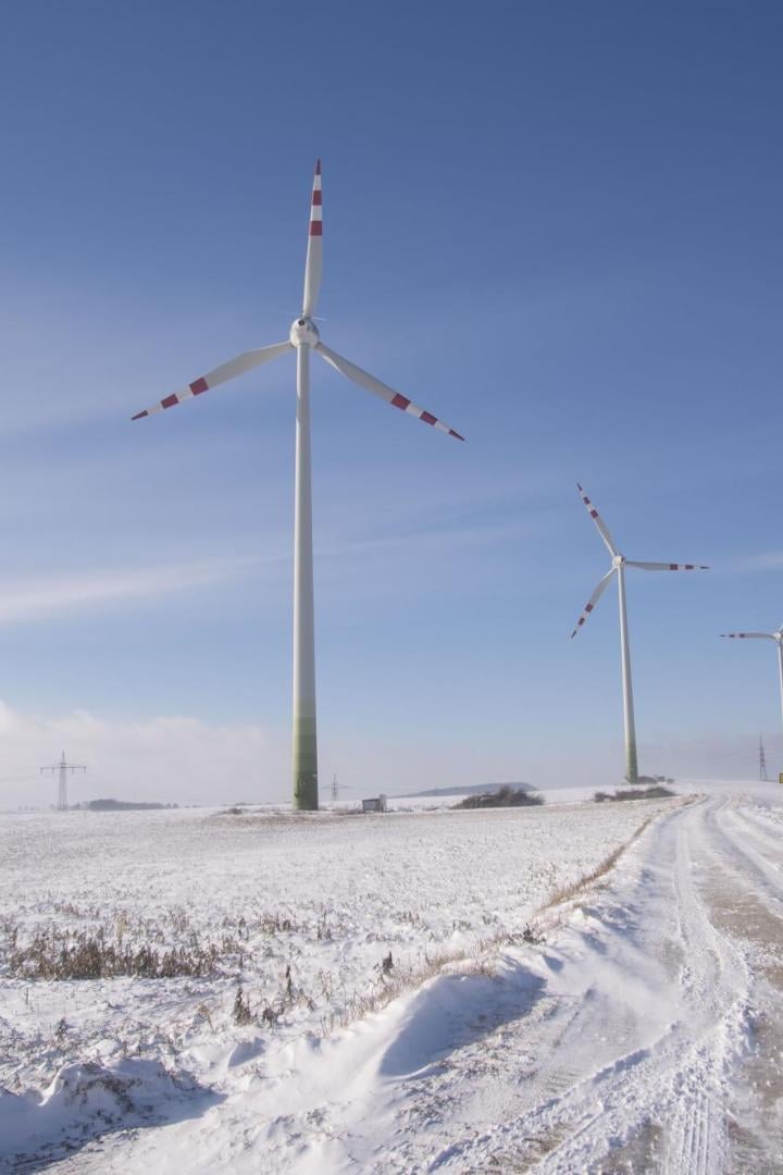Windräder auf einem verschneiten Feld