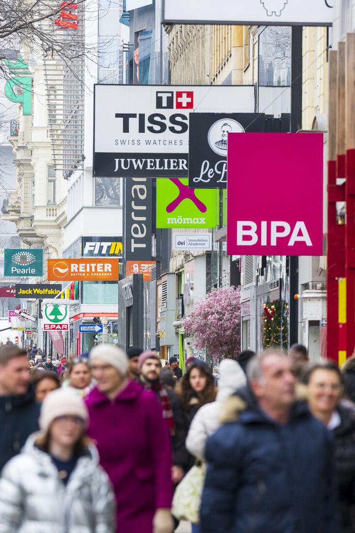 Viele Menschen flanieren auf der Mariahilfer Straße mit Geschäften wie BIPA und TISS.