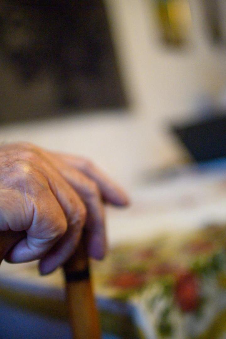 Hand eines alten Menschen an einem Gehstock