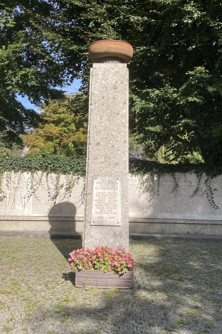 Ein KZ-Mahnmal vor einer Mauer mit Pflanzen