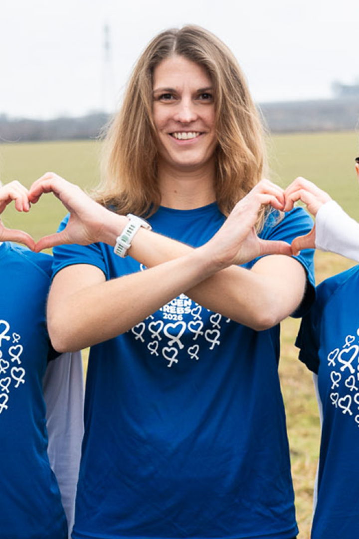 Drei Teilnehmerinnen von Laufen gegen Krebs zeigen mit den Händen Herzen in die Kamera