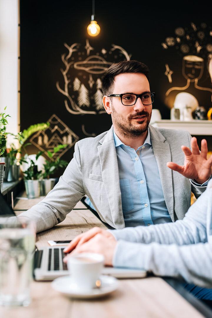 Handsome man talking to a young blonde woman at the cafe.